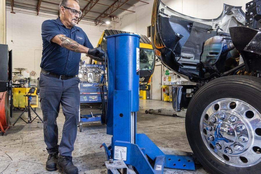 NH Repairs mechanic grinding metal component with sparks flying