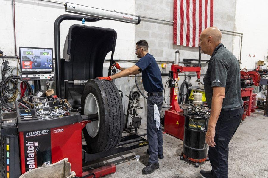 NH Repairs technician and client at Hunter wheel balancer