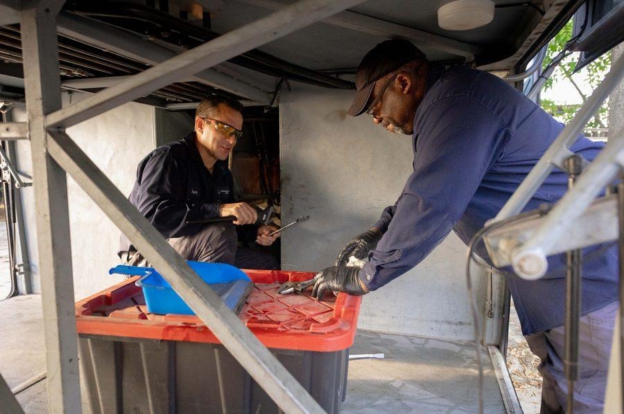 NH Repairs technicians working together on repair inside commercial vehicle trailer